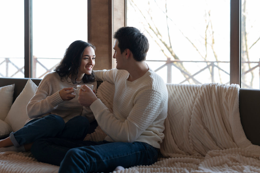 Couple sitting close together, mid-conversation, at home