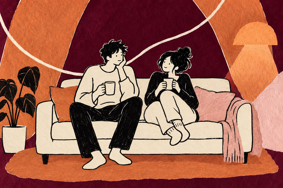 Hand-drawn illustration of a couple sitting close together on a sofa in the evening, each holding a mug, one turning to the other with a small curious smile as if about to ask something.